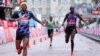 Shura Kitata, à gauche, traverse la ligne d'arrivée devant Vincent Kipchumba et Sisay Lemma au marathon de Londres, Angleterre, le 4 octobre 2020.