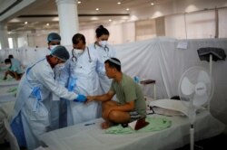 Petugas kesehatan memeriksa pasien COVID-19, warga Yahudi India, anggota Bnei Menashe dari negara bagian Manipur, India timur laut di Gurudwara (Kuil Sikh), New Delhi. (Foto: REUTERS).