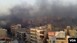 Varios edificios arden en la ciudad de Hama tras el bombardeo de los tanques.