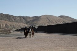 Border Patrol agents on horseback ride along a US-Mexico border fence on Jan. 31, 2020, in nearby town of Sunland Park, New Mexico.