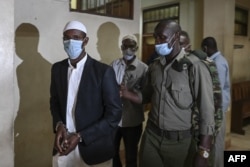 FILE - Mohamed Ahmed Abdi, left, and Hassan Hussein Mustafa, center, are escorted away after being sentenced for their involvement in the Westgate Mall attack of Sept. 2013, in Nairobi, Kenya, Oct. 30, 2020.