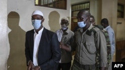 Mohamed Ahmed Abdi, left, and Hassan Hussein Mustafa, center, are escorted away after being sentenced for their involvement in the Westgate Mall attack of Sept. 2013, in Nairobi, on Oct. 30, 2020.