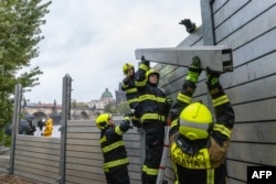 Firefighters build flood barriers on the left bank of the Vlatva River near the Charles Bridge in Prague, Czech Republic, on Sept. 13, 2024.