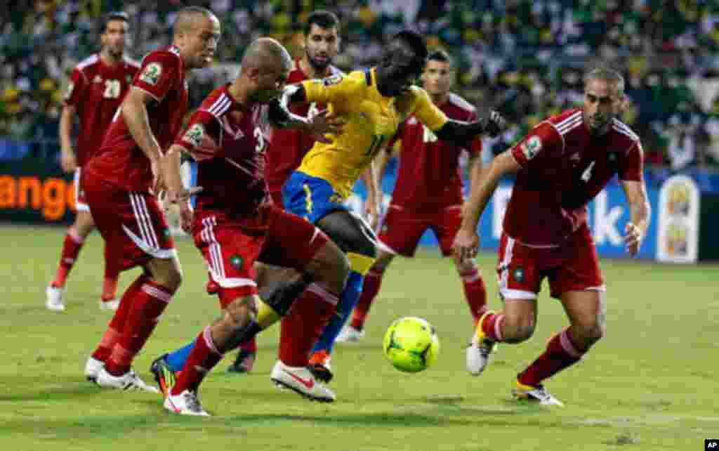 Gabon's Mouloungui dribbles the ball past a pack of Moroccan players during their African Cup of Nations soccer match at Libreville