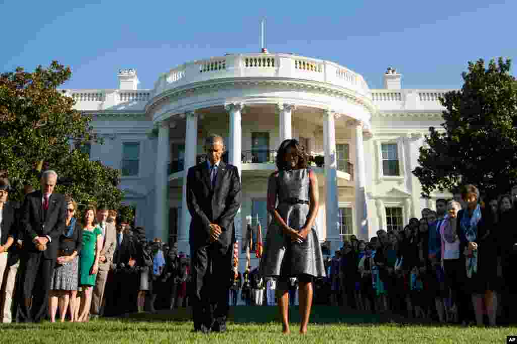 President Barack Obama, first lady Michelle Obama and others&nbsp;observe a moment of silence to mark the 14th anniversary of the 9/11 attacks, on the South Lawn of the White House in Washington, Sept. 11, 2015.