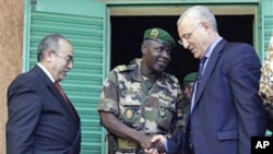 Salou Djibo (C), leader of the military junta that overthrew Niger's strongman president days earlier, shakes hands with the U.N's Said Djinnit as Ramtane Lamamra of the African Union looks on, following talks between the junta and international envoys at