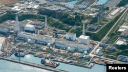 FILE - An aerial view shows the tsunami-crippled Fukushima Daiichi nuclear power plant and its contaminated water storage tanks.