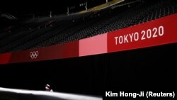 Un membre de l'équipe de sécurité monte la garde devant des stands vides au Sapporo Dome à Sapporo, au Japon, le 21 juillet 2021.