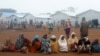 Congolese families, who fled from Democratic Republic of Congo by fleeing on a boat across Lake Albert, sit in a line at United Nations High Commission for Refugees' Kyangwali refugee settlement camp in Uganda, March 19, 2018.