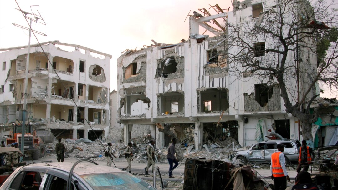 Somali soldiers walk past a destroyed building in Mogadishu, Somalia, March 1, 2019.