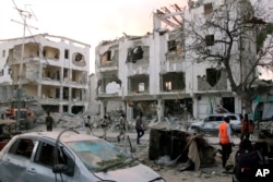 Somali soldiers walk past a destroyed building in Mogadishu, Somalia, March 1, 2019.