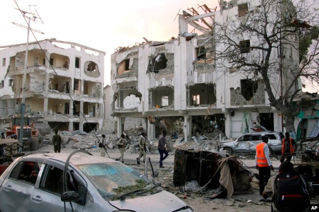 Somali soldiers walk past a destroyed building in Mogadishu, Somalia, March 1, 2019.