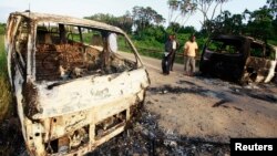 FILE - Wreckages of burnt cars are seen along the main road to Lamu from Mpeketoni after unidentified gunmen attacked the coastal Kenyan town of Mpeketoni, June 16, 2014.