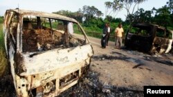 Bangkai-bangkai mobil yang dibakar di jalan dari Mpeketoni menuju Lamu, Kenya, menyusul serangan militan al-Shabab (16/6). (Reuters/Joseph Okanga)