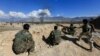 FILE - Afghan security forces take position during a gun battle between Taliban and Afghan security forces in Laghman province, Afghanistan, March 1, 2017. 