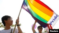 Participants hold a rainbow flag while attending Vietnam's first-ever gay pride parade, Hanoi, Aug. 5, 2012.