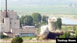 A North Korean nuclear plant is seen before demolishing a cooling tower (R) in Yongbyon, in this photo taken June 27, 2008 and released by Kyodo.