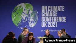 第26届联合国气候变化大会（COP26，《联合国气候变化框架公约》缔约方大会第26次会议）10月31日在英国格拉斯哥开幕。图为记者们正在为采访做准备。（法新社图）