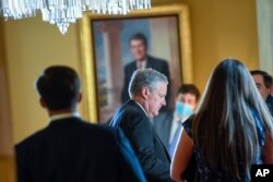 White House Chief of Staff Mark Meadows, center, waits in the office of Senate Majority Leader Mitch McConnell of Ky., on Capitol Hill in Washington, Aug. 3, 2020.