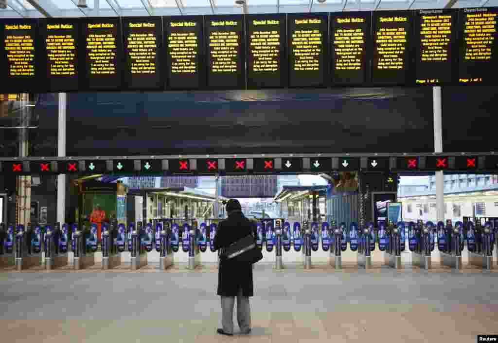 A man stands alone at London Bridge Station after numerous trains were cancelled due to storms. Disrupted transport networks and power outages wreaked havoc in Britain and France, one of the busiest travel and shopping days of the year just before Christmas, after hurricane-force winds and torrential rain lashed the region.
