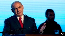 Israeli Prime Minister Benjamin Netanyahu gestures during a rally of his Likud party supporters, near Tel Aviv, Israel, Aug. 30, 2017. 