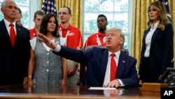President Donald Trump, accompanied by Vice President Mike Pence, Karen Pence and first lady Melania Trump, speaks during a photo opportunity with U.S. Special Olympics athletes and staff, in the White House, July 18, 2019, in Washington.