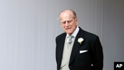 FILE - Britain's Prince Philip waits for the bridal procession following the wedding of Princess Eugenie of York and Jack Brooksbank at St George's Chapel in Windsor Castle, England.