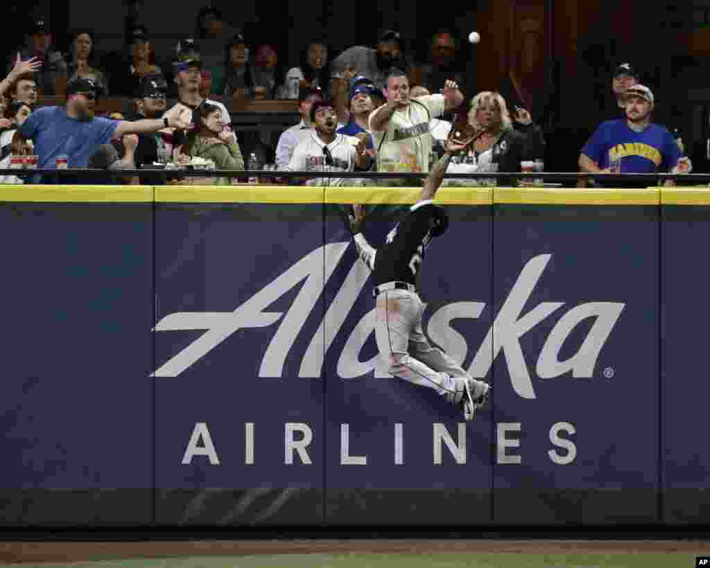 Chicago White Sox center fielder Leury Garcia leaps to rob Seattle Mariners&#39; Mitch Haniger of a home run during the ninth inning of a baseball game, July 21, 2018, in Seattle, Washington.