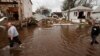 FILE - Men walk through flooding left by the storm surge of Superstorm Sandy in the New Dorp Beach neighborhood of the Staten Island borough of New York, Nov. 1, 2012.