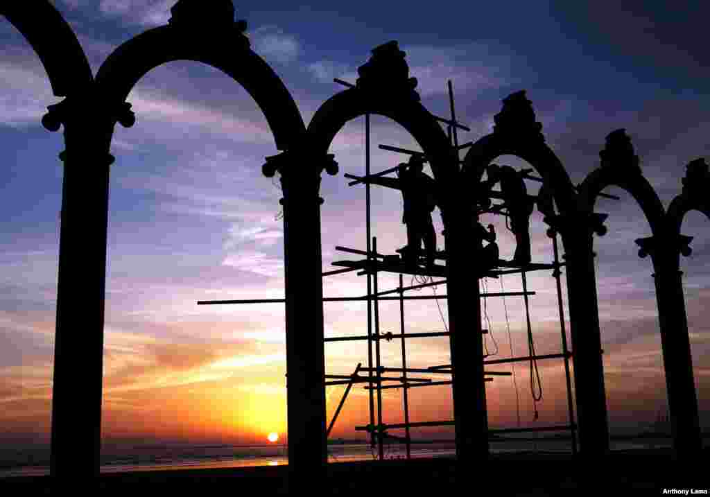 Pakistani laborers work on arches at Clifton beach in Karachi.