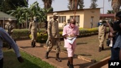 Le héros du film "Hôtel Rwanda" Paul Rusesabagina, en uniforme rose de détenu, arrive de la prison de Nyarugenge avec des agents du Service correctionnel du Rwanda à la Cour de justice de Nyarugenge à Kigali, au Rwanda, le 25 septembre 2020.