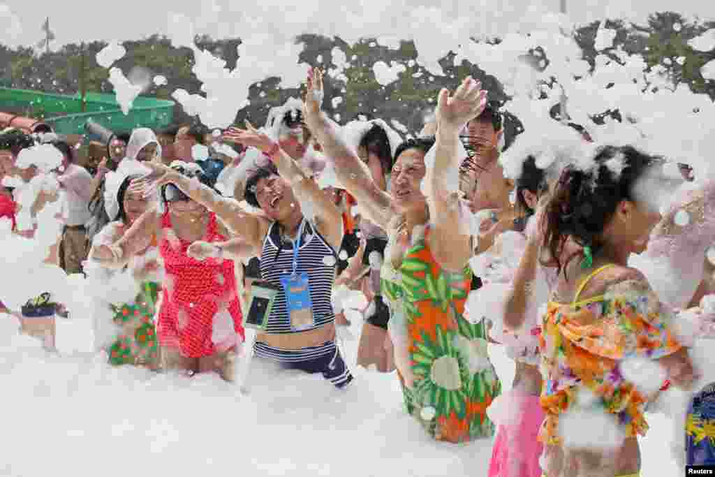 People play with foam at a water park in Yantai, Shandong province, China.