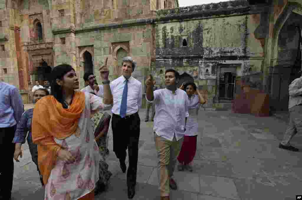 U.S. Secretary of State John Kerry with young alumni of State Department programs looks at the 14th century Tomb of Muslim rulers during their walk at Lodhi gardens, in New Delhi, June 24, 2013.
