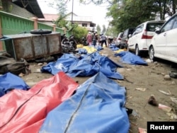 Dead bodies are seen, Sept. 29, 2018, on a street after earthquake hit in Palu, Indonesia.
