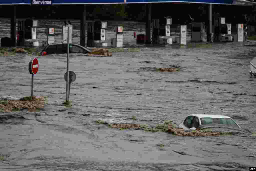 Cars are submerged in a commercial zone in Givors, central-eastern France, following heavy rainfall in the area, which is under a red alert for rain and flooding.