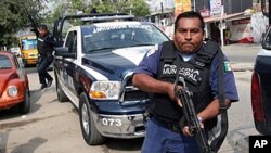 A municipal police officer during a confrontation with members of a gang in the beach resort of Acapulco, Mexico, 8 Jan 2011.