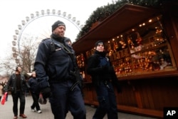 Police officers patrol a Christmas market near the city hall in Berlin, Wednesday, Dec. 21, 2016