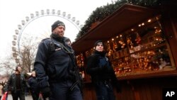 Police officers patrol a Christmas market near the city hall in Berlin, Wednesday, Dec. 21, 2016