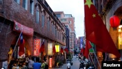 FILE - Chinese and Taiwanese flags are displayed around souvenir shops in Kinmen, Taiwan, Aug. 19, 2018.