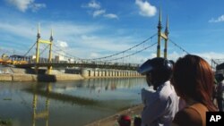 Cambodians look on Diamond Bridge, which some now call 'Bridge of Ghosts', on November 23, 2010, one day after the deadly stampede that killed more that 300 festival goers. Preliminary investigation shows the narrow bridge's swaying caused the panic, offi