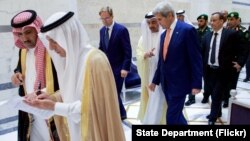 ລັດຖະມົນຕີການຕ່າງປະເທດ ສະຫະລັດ ທ່ານ John Kerry ຍ່າງໄປກັບ ຮອງລັດຖະມົນຕີການຕ່າງປະເທດ ຂອງອັງກິດ ທ່ານ Tobias Ellwood ແລະລັດຖະມົນຕີການຕ່າງປະເທດ ສະຫະລັດ ອາຣັບ ເອເມີເຣັສ ທ່ານ Abdullah bin Zayed ເມື່ອວັນທີ 25 ສິງຫາ 2016, ໃນ ສະຖານທີ່ຕ້ອນຮັບກະສັດ ຢູ່ທີ່ ສະໜາມບິນສາກົນ ກະສັດ Abdulaziz.