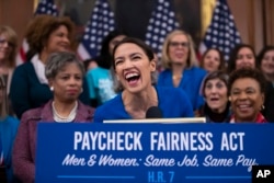 Rep. Alexandria Ocasio-Cortez, D-N.Y., smiles as she speaks at an event to advocate for the Paycheck Fairness Act on the 10th anniversary of President Barack Obama signing the Lilly Ledbetter Fair Pay Act.