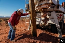 Ryan Smith, left, a foreman with the Navajo Tribal Utility Authority, checks the extent  of a powerfulness  rod  during construction, Oct. 9, 2024, connected  the Navajo Nation successful  Halchita, Utah.