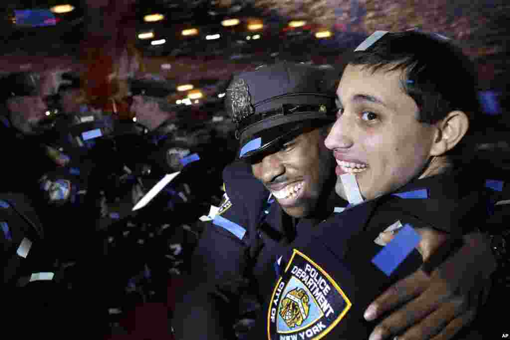 New police officers hug and celebrate as confetti falls, during their graduation ceremony at the Beacon Theater in New York.