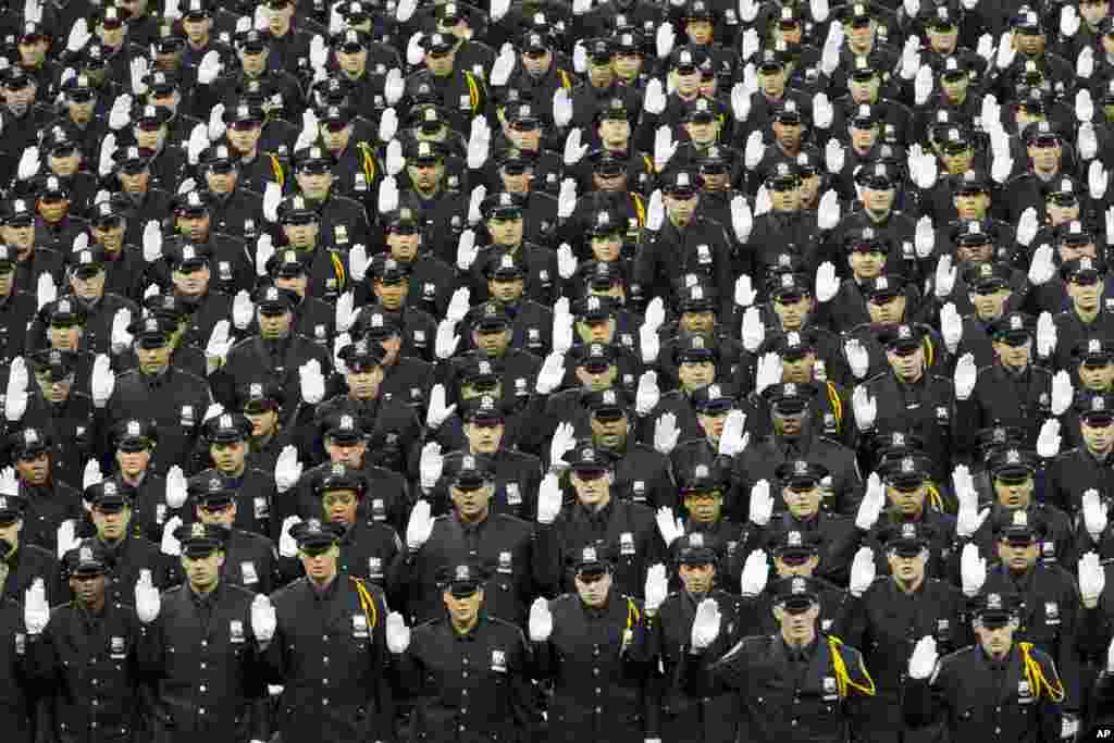 New police officers take the oath of office during the New York City Police Department Police Academy graduation ceremony at Madison Square Garden in New York.