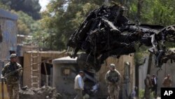 Fuerzas aliadas remueven un vehículo dañado por la explosión de un coche bomba en Kabul, Afganistán, el jueves, 5 de septiembre, de 2019.