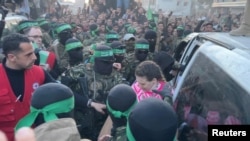 Palestinian Hamas militants hand over hostages kidnapped during the Oct. 7, 2023, attack on Israel, to members of the International Committee of the Red Cross (ICRC) in Gaza City, Jan. 19, 2025 in this screen grab from a video. 