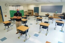 Todd Jones, asisten direktur di Fairfax County Public Schools, di sebuah ruang kelas yang mejanya sudah ditata untuk mencegah penyebaran virus corona, SD Mantua, di Fairfax, Virginia, 17 Juli 2020. (Foto: Reuters)