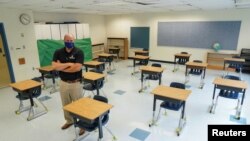 Todd Jones, asisten direktur di Fairfax County Public Schools, di sebuah ruang kelas yang mejanya sudah ditata untuk mencegah penyebaran virus corona, SD Mantua, di Fairfax, Virginia, 17 Juli 2020. (Foto: Reuters)