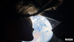 2026년 4월 4일 아르테미스 2호의 미션 전문가인 NASA 우주비행사 크리스티나 코크가 오리온 우주선 실내 창밖으로 지구를 바라보고 있다.